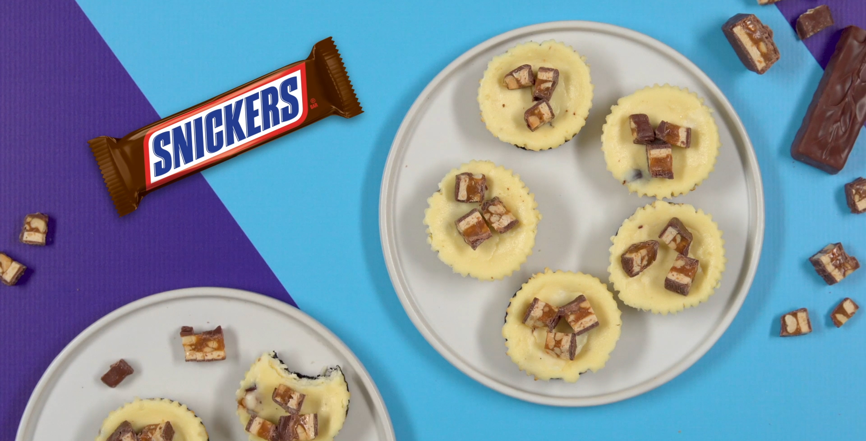 Birds eye view of Snickers cheesecake cups next to a classic snickers bar