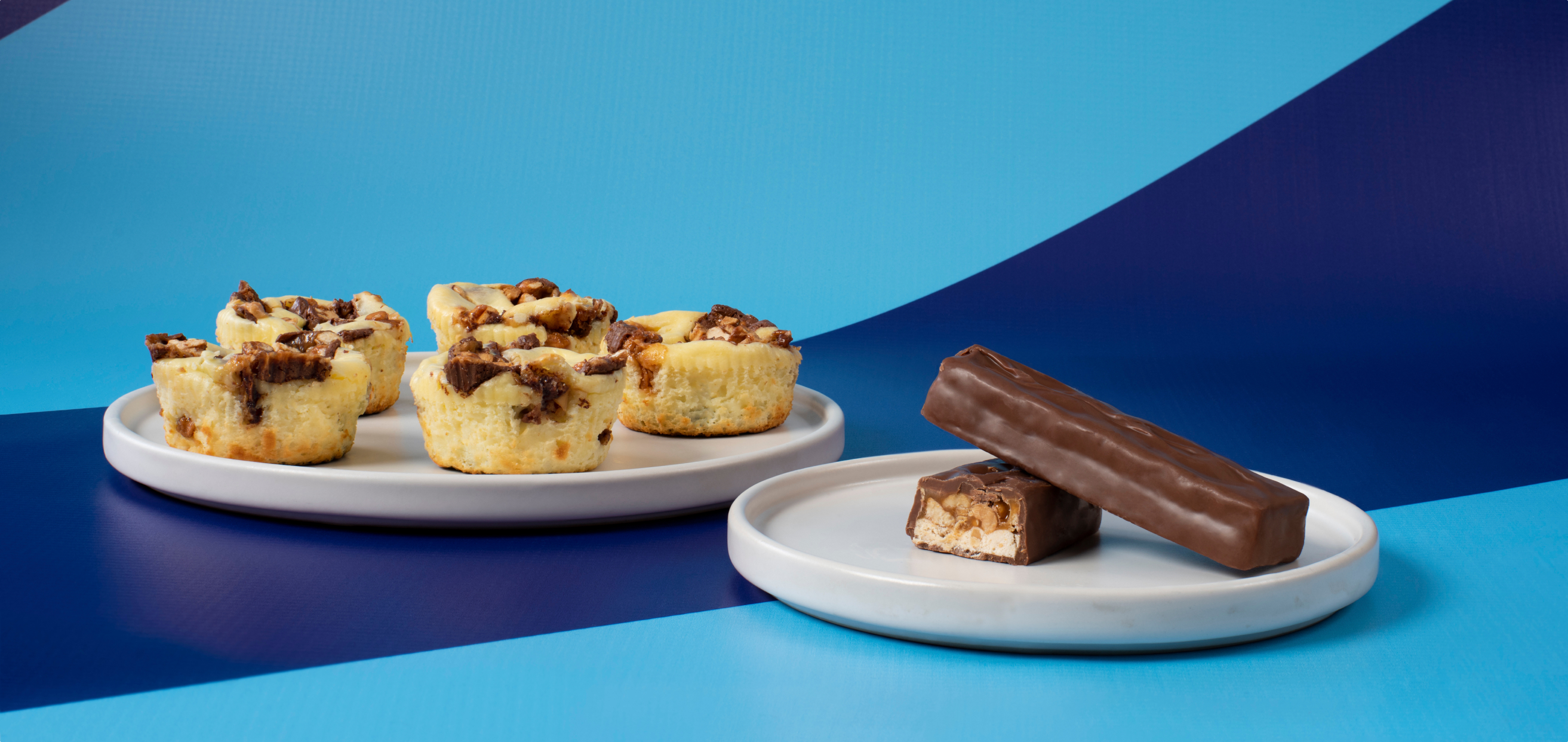 Snickers cheesecake cups next to cross section of a classic snickers bar