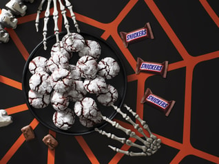 Snickers blood red crinkle cookies next to Halloween decorations